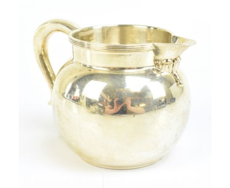 A George V hallmarked silver cream jug of bulbous form with cast rim, London 1931, retail for Wilson &amp; Sharp Ltd, Edinbur