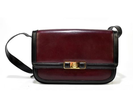 CELINE; a burgundy red calfskin leather shoulder bag with black leather trim and shoulder strap, gold tone hardware including