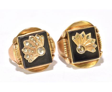 A very near pair of gentleman's yellow metal signet rings, each set with a rectangular black onyx platform surmounted with cr