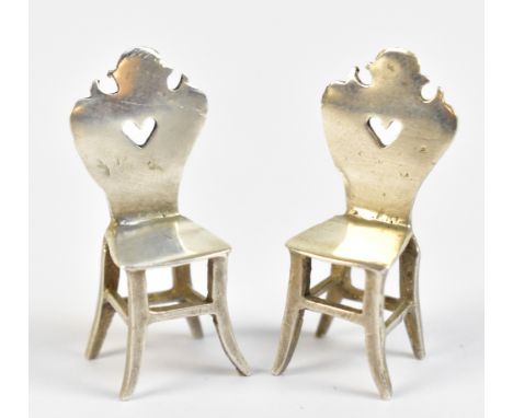 BERTHOLD MULLER; a pair of Victorian hallmarked silver miniature doll's house chairs with pierced hearts to the shaped backs,