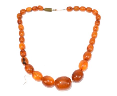 A vintage graduated butterscotch/egg yolk amber coloured bead necklace, length 42cm, largest bead 25 x 20mm, smallest bead 12