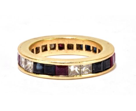 A yellow metal diamond, ruby and sapphire full eternity ring, the channel setting with eight diamonds, eight rubies and eight