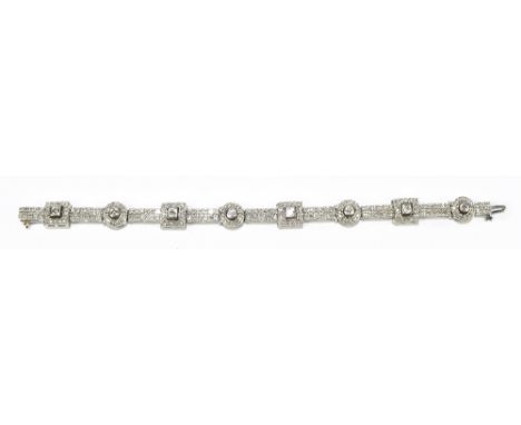 A 14ct white gold diamond set bracelet, the articulated frame set with a series of pierced square and round panels interspers