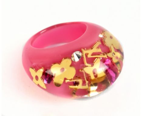 LOUIS VUITTON; a pink and clear resin dress ring inset with gold toned LV monogram and flowers, size M, in branded box.Additi