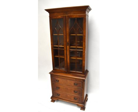 A reproduction mahogany veneered display cabinet, the pair of astragal glazed doors enclosing three adjustable shelves above 