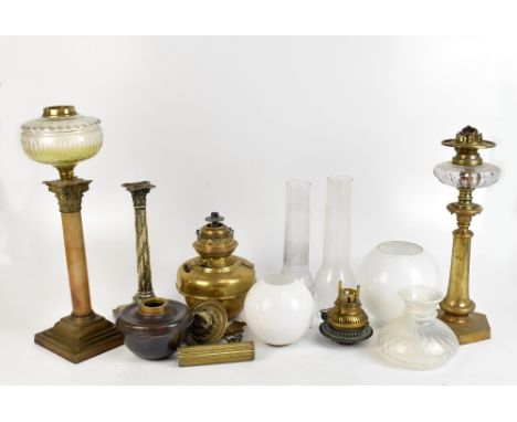 Four oil lamp bases, the tallest with clear cut glass reservoir above Corinthian-style capital to stone column on stepped squ