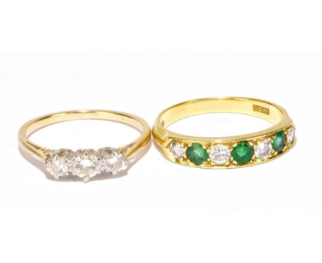 An 18ct yellow gold diamond and emerald seven stone ring, size M, together with a yellow metal ring with three white stones, 