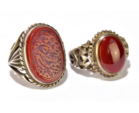 Two white metal and carnelian set gentleman's rings, one with large oval panel set with Arabic writing, size P1/2, the second