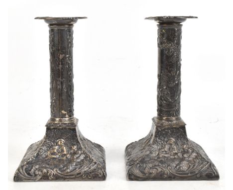 WILLIAM COMYNS; a pair of late Victorian hallmarked silver candlesticks with repoussé decoration of a lady and musician in Ar