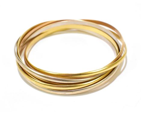 CARTIER; an 18ct three tone seven band trinity bangle, signed, numbered 963940-62, internal width approx 62mm, approx 73.4g.A