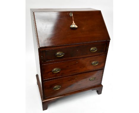 A late 19th century mahogany bureau, the fall front enclosing fitted interior above two brush slides and three drawers on oge