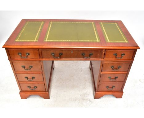 A reproduction mahogany veneered twin pedestal desk with an arrangement of nine drawers on ogee bracket feet, height 74cm, wi