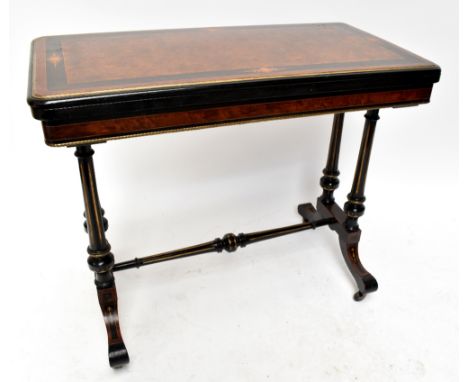 A Victorian Aesthetic Movement amboyna, ebonised and inlaid fold-over card table with gilt detail in the style of Lamb of Man