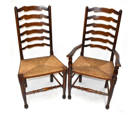 A good set of eight reproduction ash and beech ladder back dining chairs with rush seats on turned and stretchered supports (