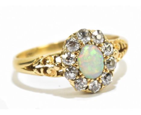 A yellow metal diamond and opal ring, the central opal flanked by ten diamonds, approx size N, approx 2.8g.Additional Informa