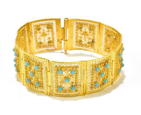 A yellow metal turquoise set filigree decorated panel bracelet, each panel set with five small turquoise cabochons and with p