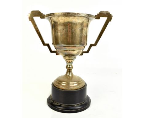 G. BRYAN &amp; CO; an Art Deco hallmarked silver twin handled pedestal trophy cup with cast rim and stepped twin handles, Bir