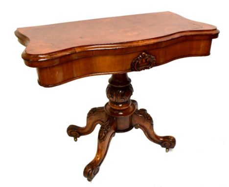 A Victorian burr walnut veneered serpentine fronted card table, raised on carved baluster column to outswept supports, length