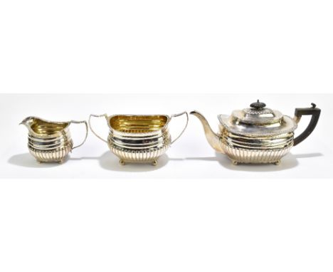 THOMAS HAYTER; a George III hallmarked silver three piece tea service with gadrooned decoration, raised on ball feet, London 