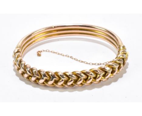 A 10ct rose gold hinged snap bangle with the upper portion of rope twist design, exterior width 70mm, interior approx 60mm, a