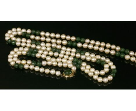 A single row uniform cultured pearl and jade bead necklace, with sets of seven 8 to 8.5mm cultured pearls strung knotted betw