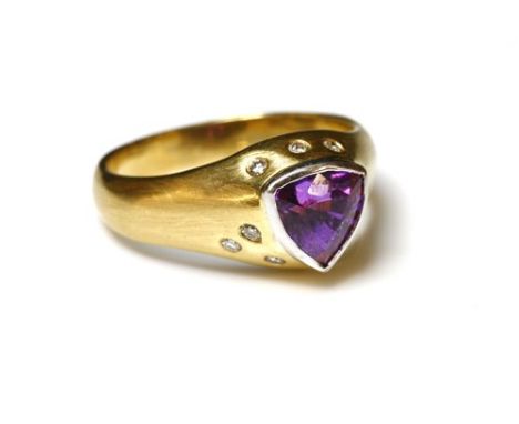 An 18ct yellow and white gold, sapphire and diamond ring, with a trilliant-shaped sapphire, rub set to the centre. Purple to 