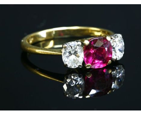 An 18ct gold, three stone ruby and diamond ring by Kutchinsky, with an old circular mixed cut ruby, four claw set to a yellow