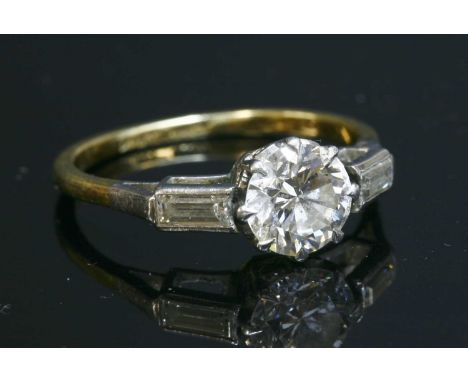 A single stone diamond ring with baguette cut diamond shoulders, a brilliant cut diamond, estimated as approximately 0.95ct, 