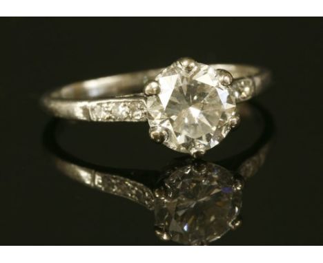 A single stone diamond ring with diamond set shoulders, with a brilliant cut diamond, estimated as approximately 1.59ct, six 