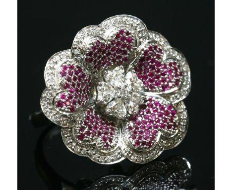 A white gold, diamond and ruby flower head cocktail ring, with a central cluster composed of a brilliant cut diamond surround