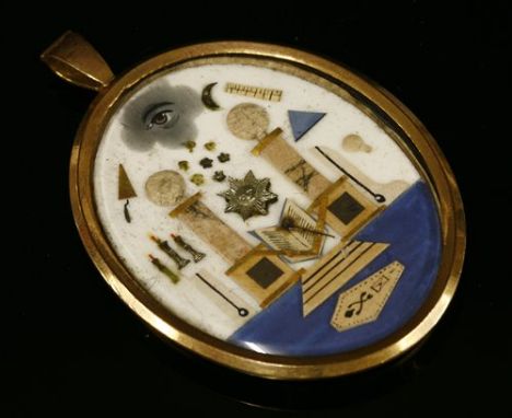 A Georgian gilt metal masonic pendant, c.1800-1820, with cut paper and applied symbols to include Eye, Moon and Seven Stars, 