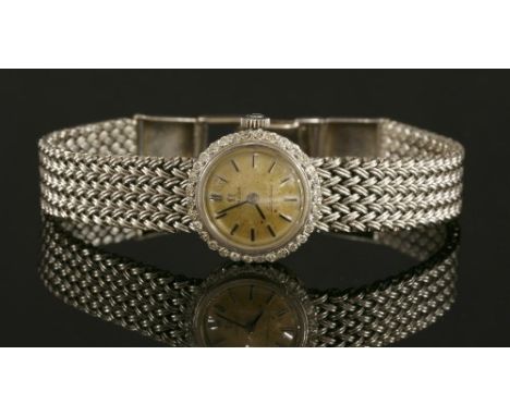 A ladies' 18ct white gold diamond set Omega 'Ladymatic' mechanical bracelet watch, c.1960, with a circular silvered dial. Rai