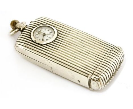 A sterling silver travelling clock vesta case, a silver vesta case set with a top wind travelling open face clock, white enam