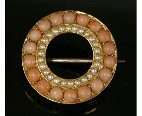 A late Victorian gold, coral and split pearl circle brooch, c.1900, with an outer row of circular cabochon angel skin coral. 