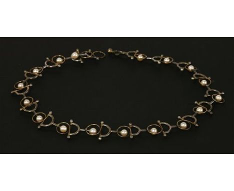 A cased sterling silver, 18ct gold and cultured pearl necklace, c.1990, by Brett Payne. A series of articulated crescent link