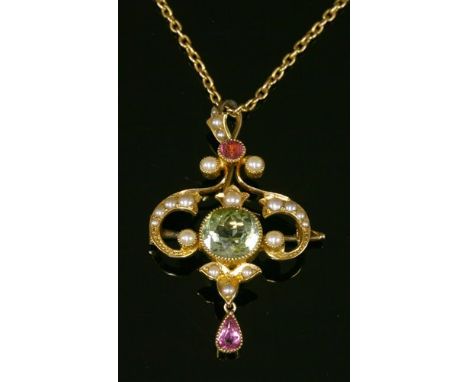An Edwardian green tourmaline, pink tourmaline and split pearl brooch/pendant, c.1905, of scrolling cartouche form. A circula