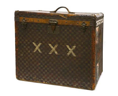 An early 20th century French leather-bound trunk, possibly by Goyard, the exterior in a chequered canvas, leather edges and c