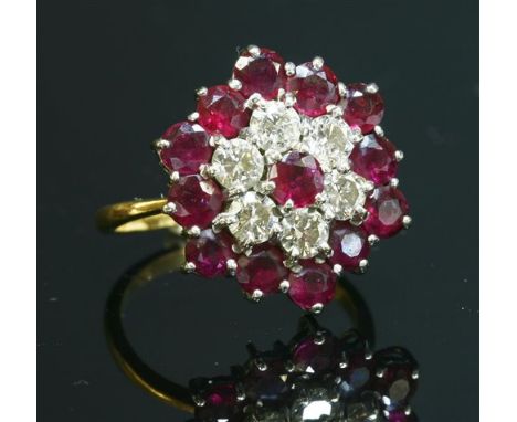 A gold, ruby and diamond hexagonal cluster ring, with a circular mixed cut ruby, claw set to the centre to a lower tier of br