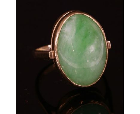 A 9ct gold single stone jade ring, with an oval jade cabochon, rub set to a plain collet with a milled setting edge, with ope