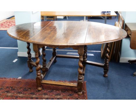 A large heavy oak gate-leg dining table with barley twist legs, together with a set of eight upholstered dining chairs (6+2) 