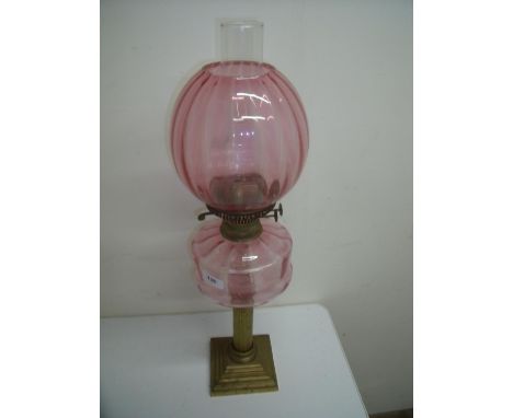 Brass column cranberry glass oil lamp on stepped square base (65cm high) 