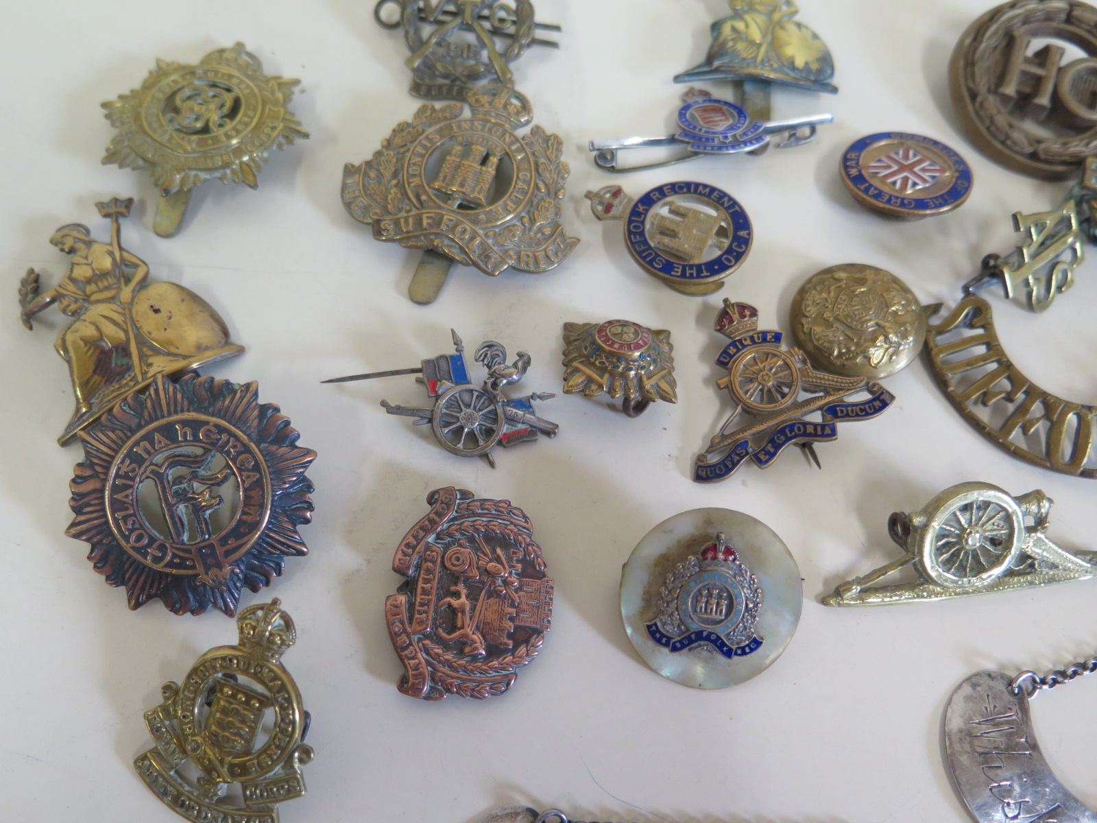 A collection of approximately 20 military cap badges with some enamel ...