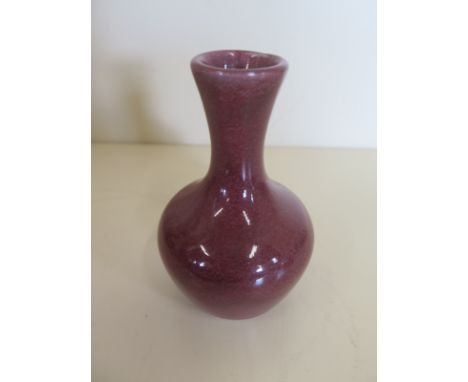 A small Moorcroft experimental stoneware spill vase, with a sang de boeuf glaze, approximately 10 cm high, without box and wi