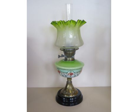 An early 20th century oil lamp with green glass shade and chimney, approximately 58cm high, see images for condition 