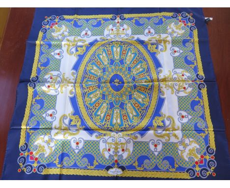 A Patik Philippe silk scarf with blue and gold decoration, approximately 85cm square, in good condition.