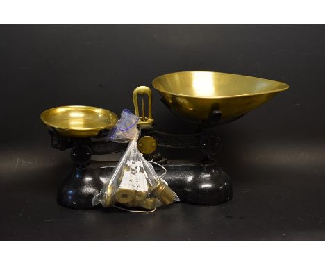 A set of brass and cast iron kitchen scales with a set of graduated bell shaped weighs