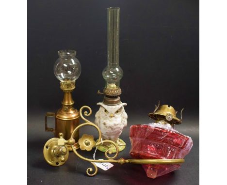 Lighting - a Continental pottery owl lamp, crossed swords mark; a French oil lamp; a Cranberry class and brass oil lamp wall 