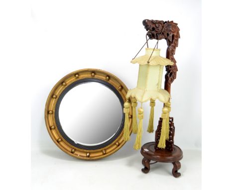 A 20th century Chinese carved hardwood lamp stand in the form of a dragon, height 72cm, and a convex mirror (2).