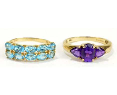 A 14ct yellow gold and blue topaz ring set with ten oval cut stones in high claw settings with pierced shanks, size O1/2, and