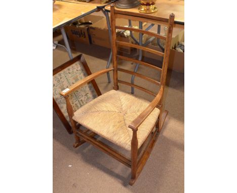 An oak rush seated ladder back rocking chair.